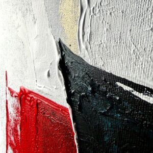 Nowoczesny obraz abstrakcyjny z czarną centralną formą, białym tłem oraz akcentami czerwieni, złota i niebieskiego, utrzymany w minimalistycznym stylu zbliżenie